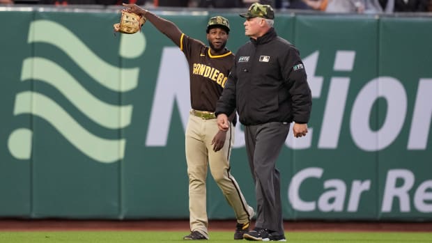 Padres left fielder Jurickson Profar (10) talks to second base umpire Ted Barrett (65) after baseballs were thrown onto the field during the third inning against the Giants.
